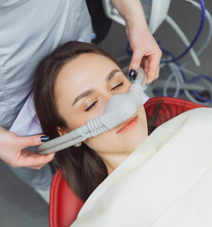 Dental assistant placing nasal mask over patient's nose