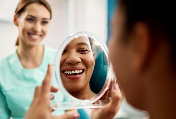 Patient smiling at reflection in treatment chair