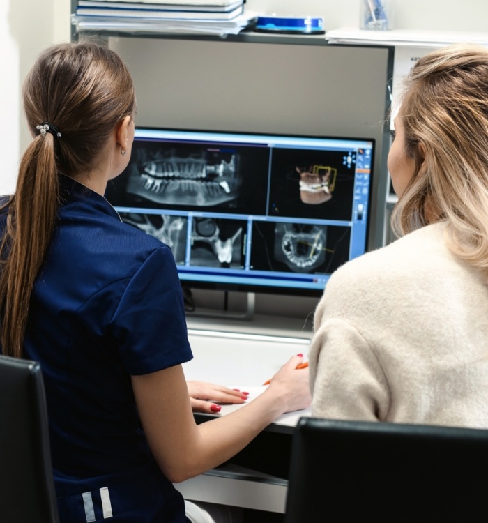 Dental team members looking at digital x rays