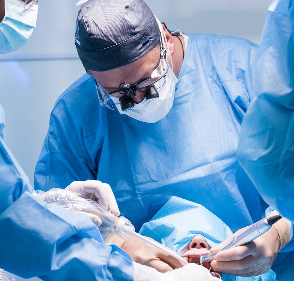 Dental surgeon placing dental implants in patient’s mouth