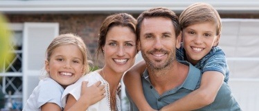 Family of four smiling outdoors