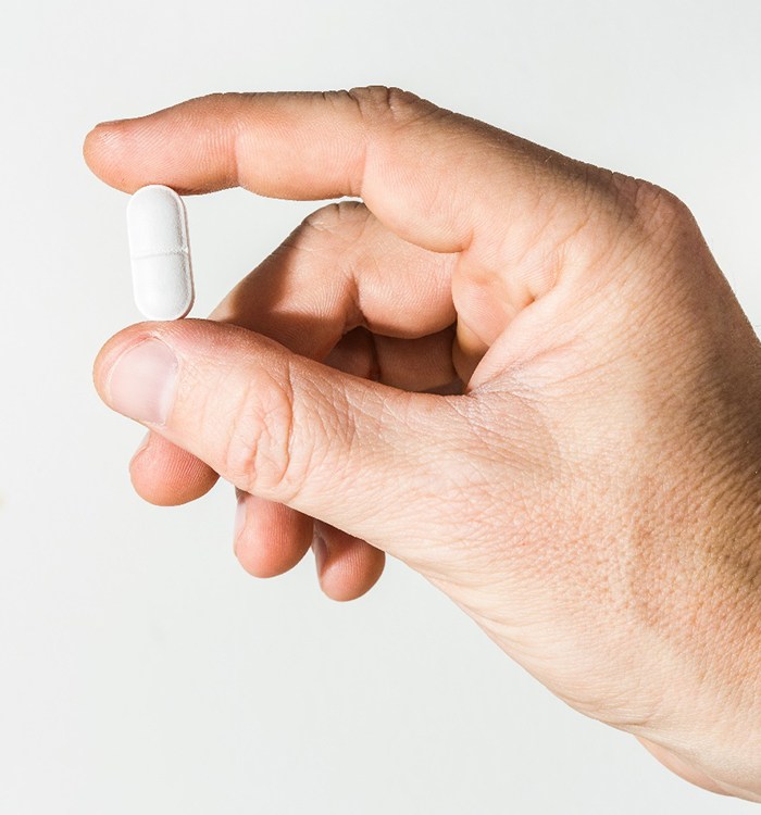 Patient holding up white pill