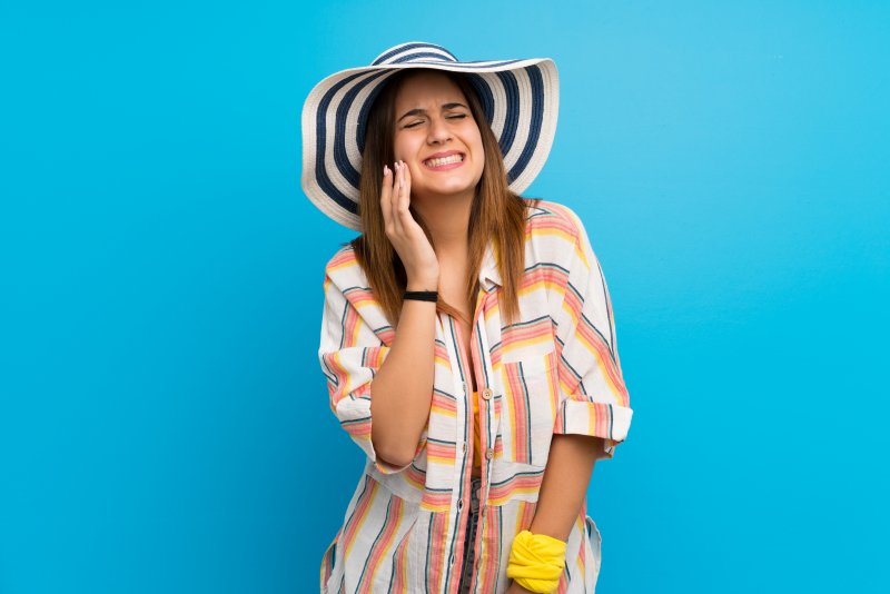 a woman with a dental emergency during summer vacation