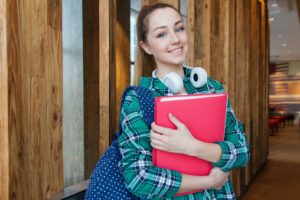 Young female student holding red folders