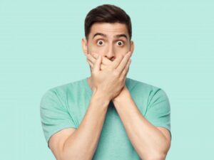 Man covering his mouth after his filling fell out